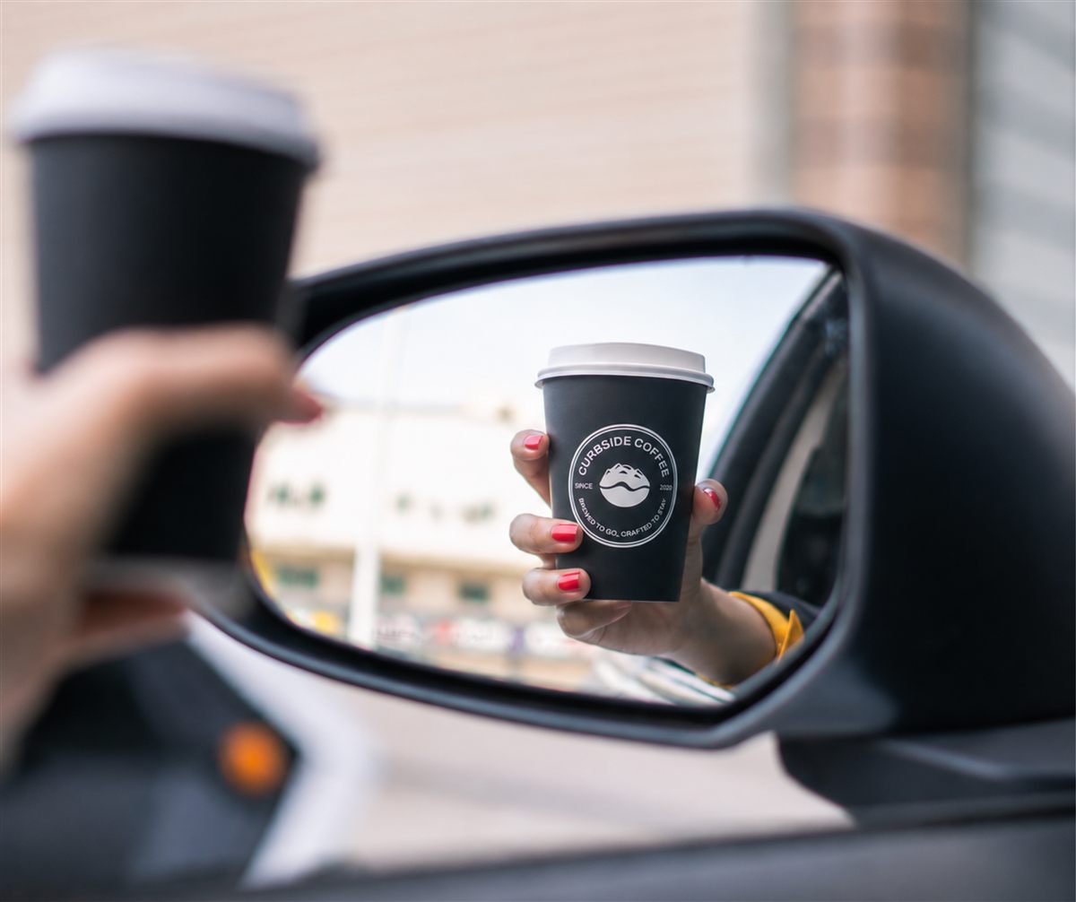 Curbside Coffee cup reflected in a car mirror